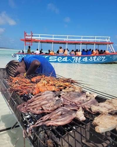 Travelers wading in the crystal-clear turquoise shallows off the Malindi coast